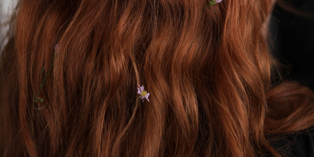Rich auburn waves adorned with delicate pink flowers, illustrat