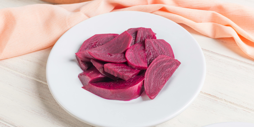 "Sliced cooked beetroot on a white plate, a key natural ingredient for homemade dark red hair dye
